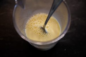 Milch und Ei Mischung für Pancakes in einem Rührbecher